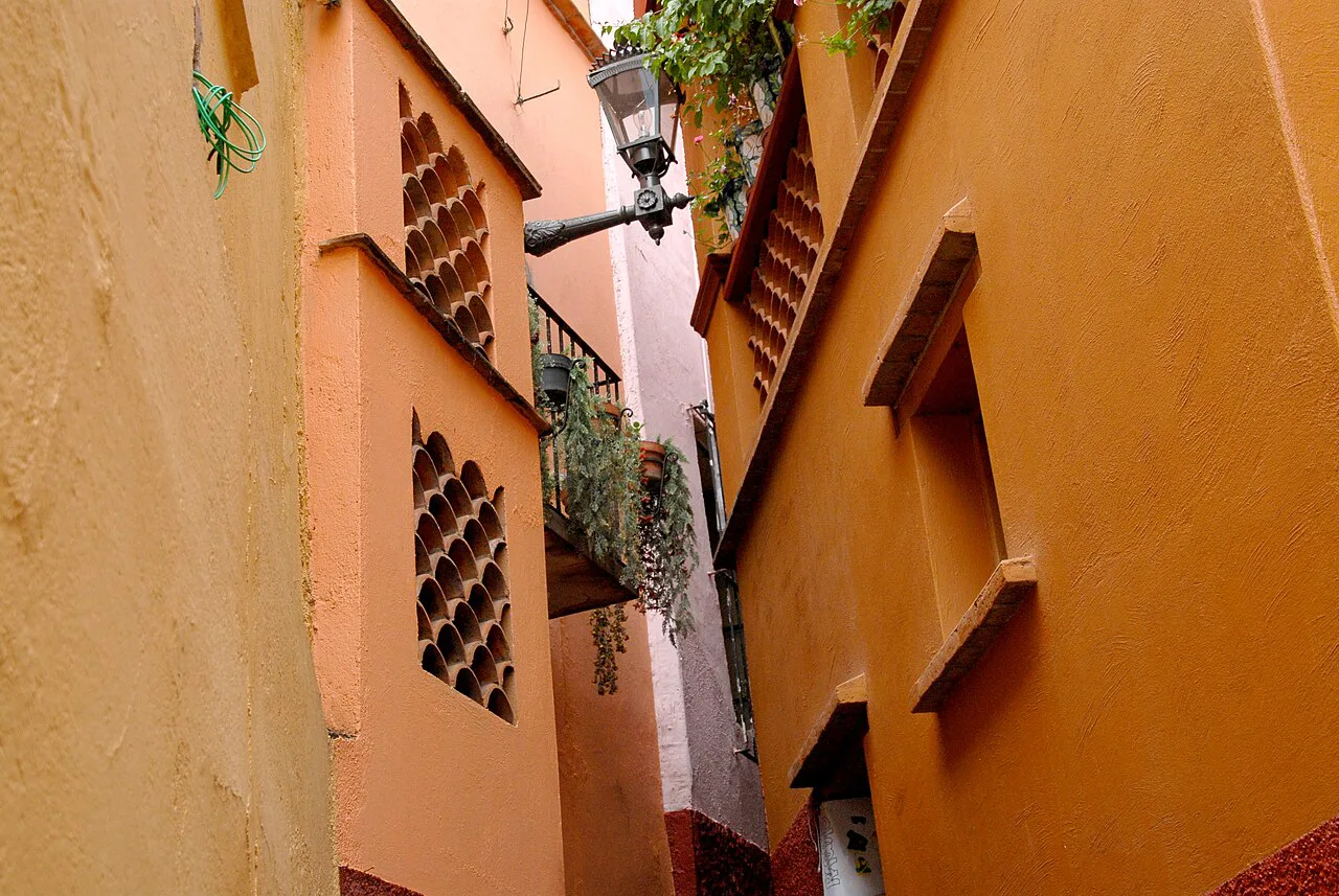 Orange walls and balconies nearly touching above the Callejón del Beso, Guanajuato.