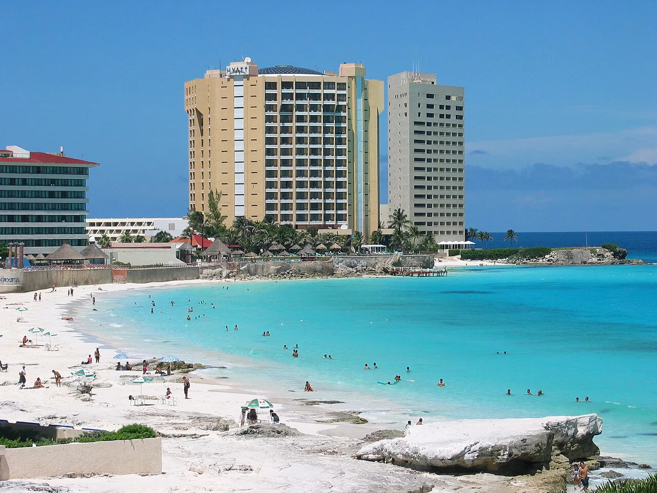 Turquoise water and hotel towers on a beach in Cancún.