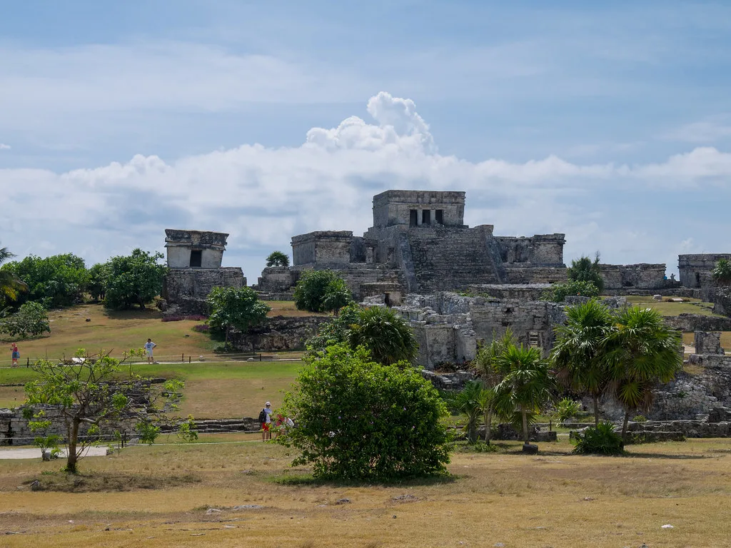 Maya ruins on the grassy grounds of the Tulum archaeological site.