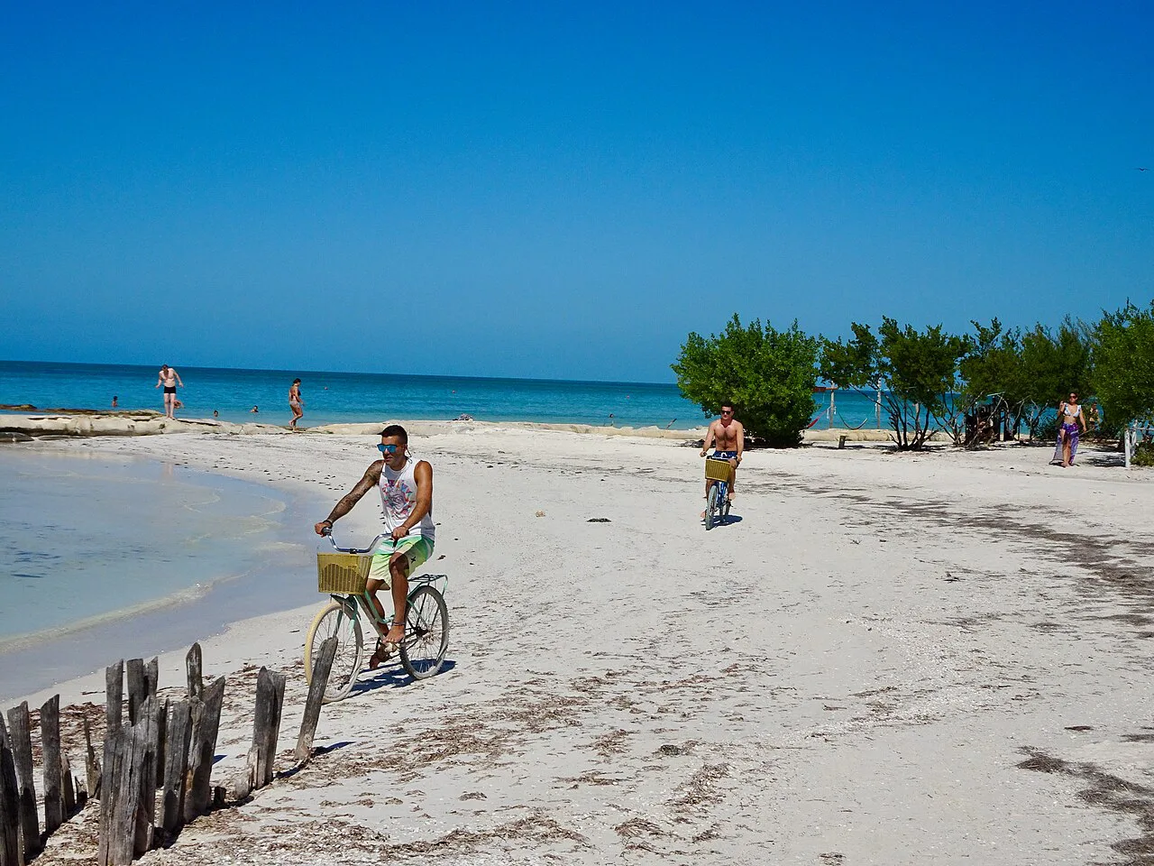 A cyclist on a sandy beach on Holbox Island.