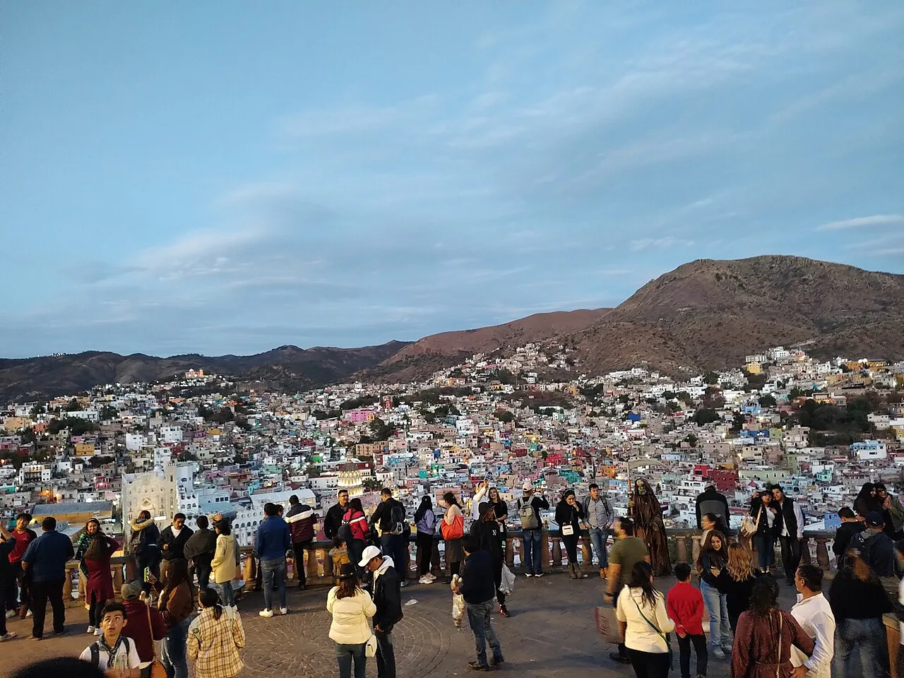 Visitors at the Pípila monument lookout over Guanajuato's hillside houses.