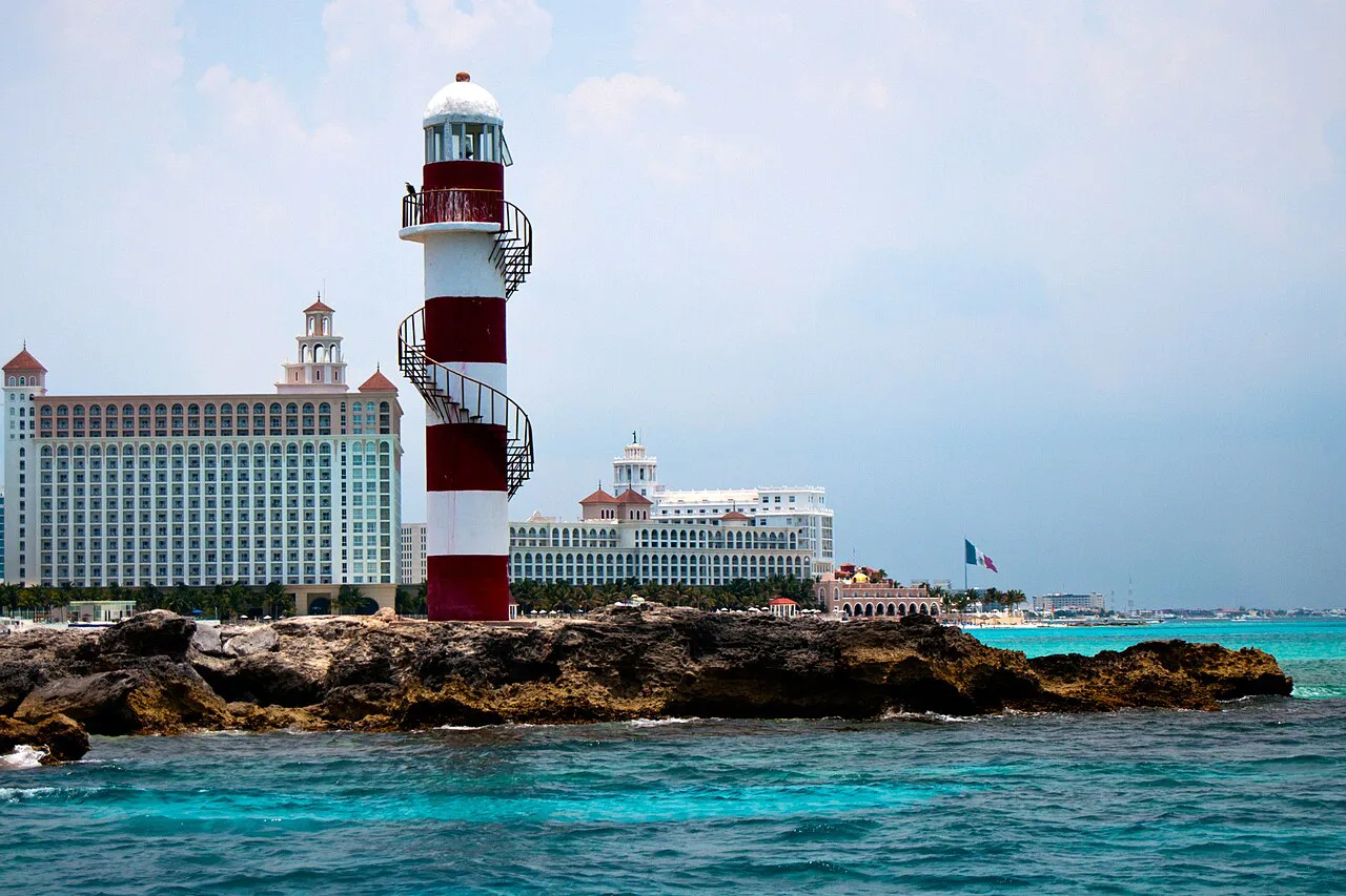 Red-and-white lighthouse and hotels at Punta Cancún.