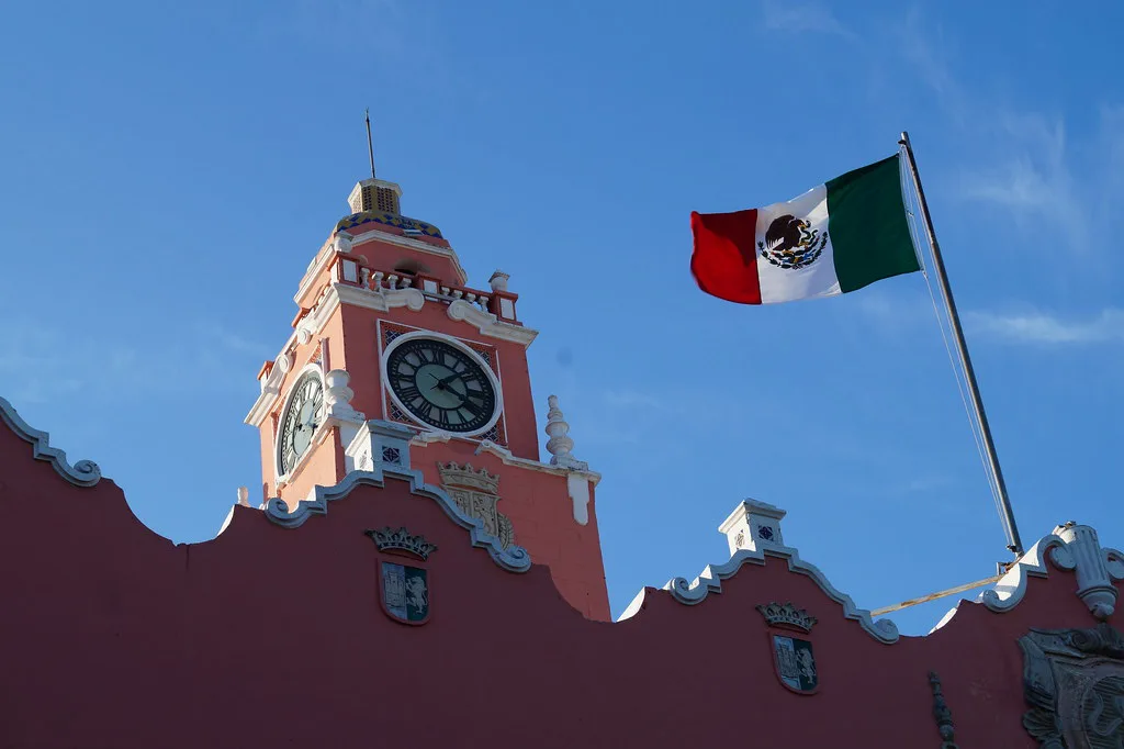 Clock tower of the Palacio Municipal in Mérida with the Mexican flag.