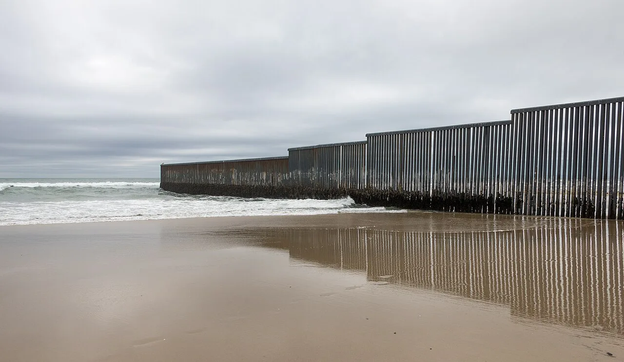 The Mexico–US border wall running into the Pacific at Tijuana.