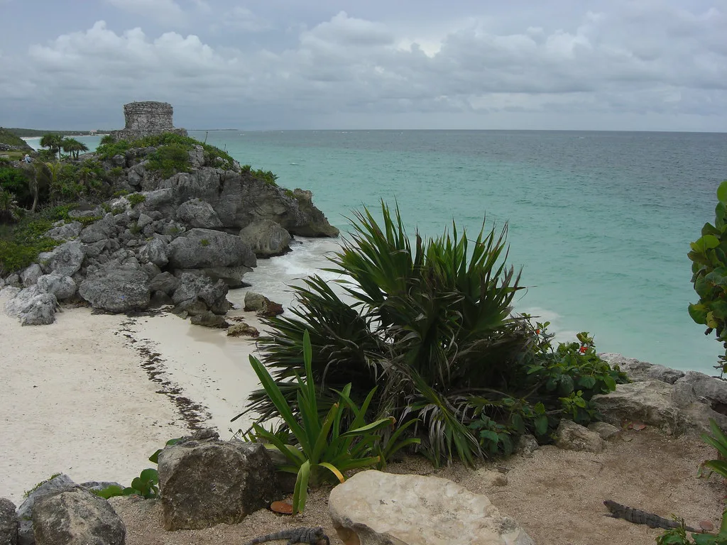 Tulum's clifftop Maya ruins above a white-sand beach and turquoise sea.