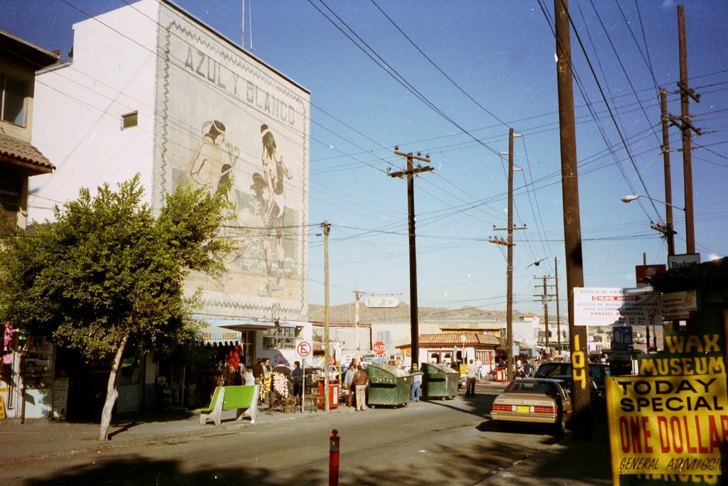 Street with a painted mural and a wax museum sign in downtown Tijuana.